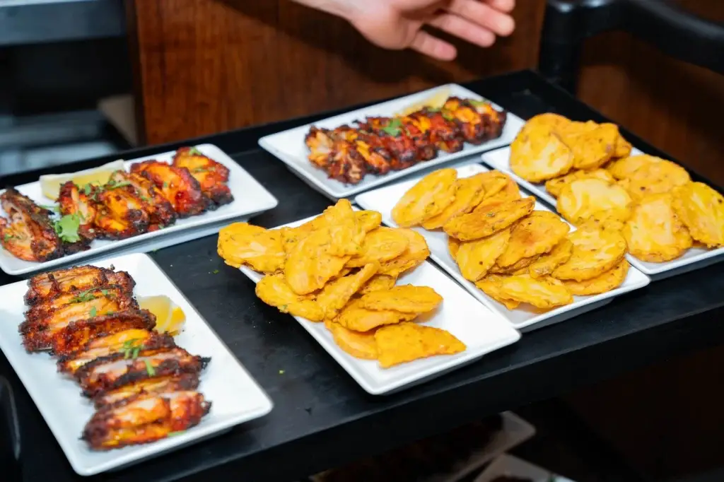 Platters of tandoori chicken and paneer starters ready for a party order
