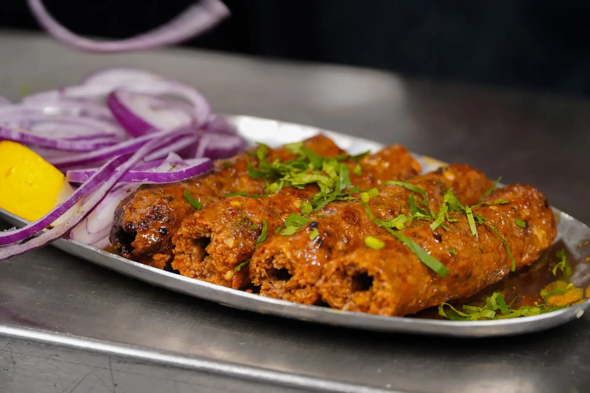 Seekh kebab with onions and lemon at Dawat Bar and Kitchen