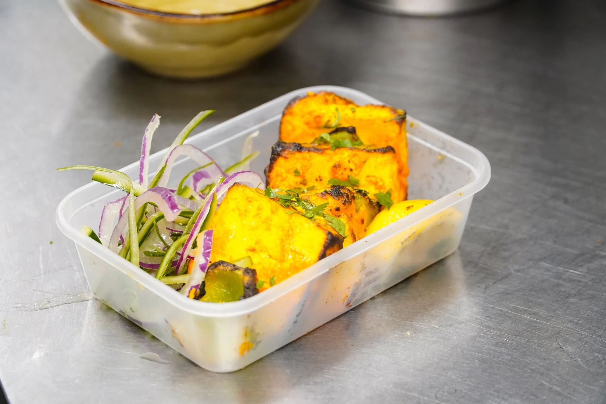 Tikka with salad in a takeaway box from Dawat Bar and Kitchen